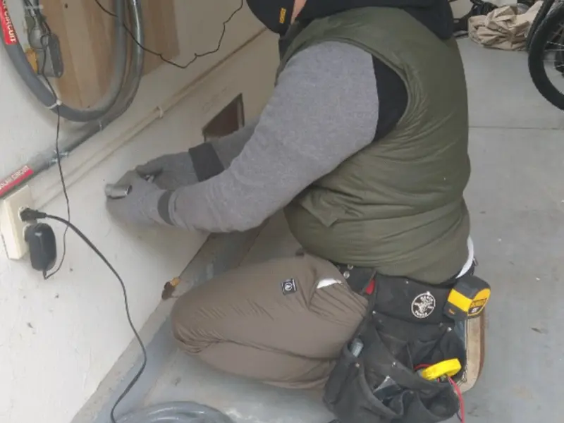 Electrician performing outlet wiring in a Bowling Green garage